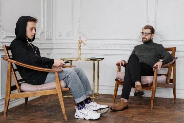 Photo by cottonbro studio: https://www.pexels.com/photo/man-in-black-sweater-and-blue-denim-jeans-sitting-on-brown-wooden-chair-4100638/