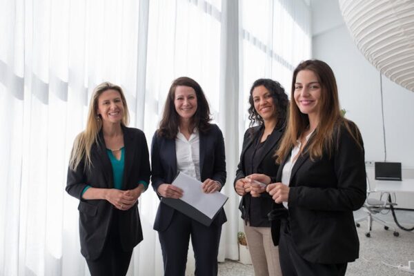 Photo by Kampus Production: https://www.pexels.com/photo/a-group-of-women-standing-and-smiling-while-wearing-corporate-attire-8171224/